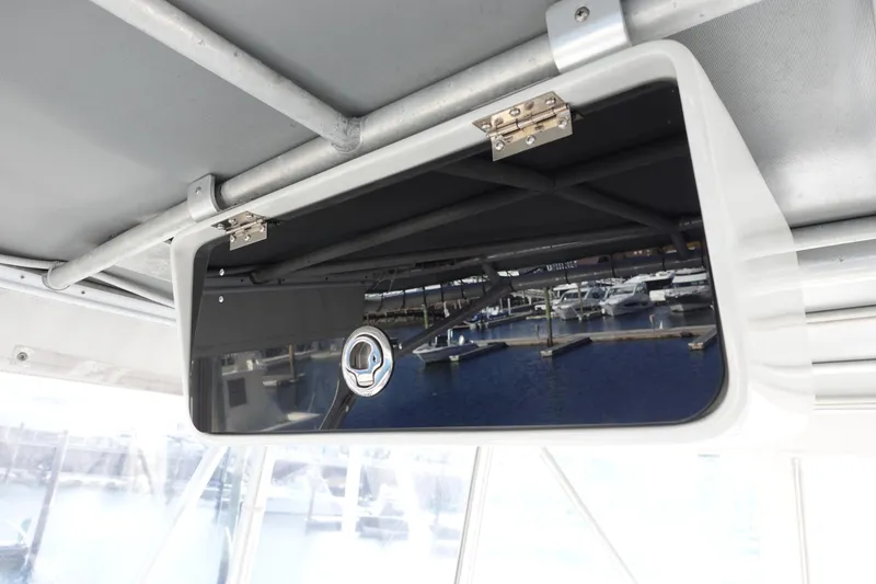 Slide: The Image of 2001 Luhrs 36 Convertible boat interior storage compartment with marina view reflection. - 18