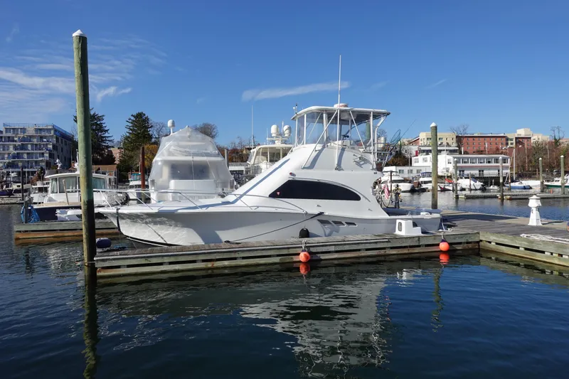 Slide: The Image of 2001 Luhrs 36 Convertible yacht docked in a marina under clear blue skies. - 2