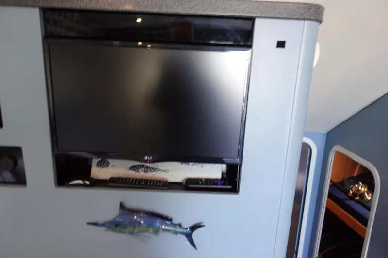 Slide: The Image of 2001 Luhrs 36 Convertible interior with mounted TV and marlin decoration. - 22