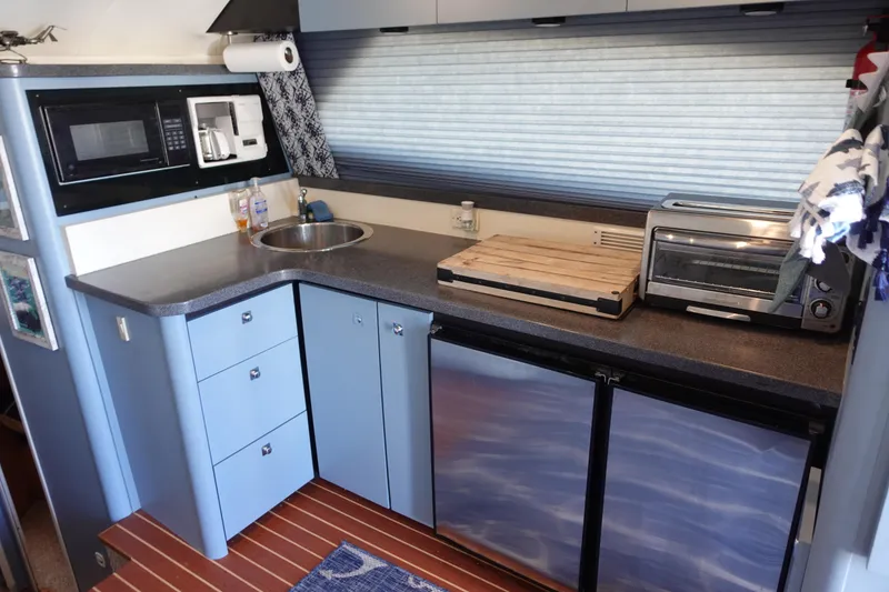 Slide: The Image of Kitchen area of 2001 Luhrs 36 Convertible boat with modern appliances and compact design. - 23