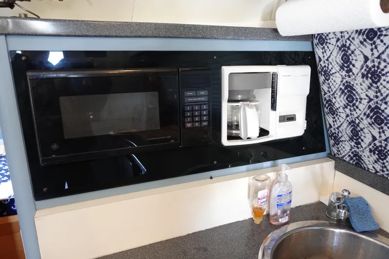 Slide: The Image of Kitchen area in a 2001 Luhrs 36 Convertible with microwave and coffee maker. - 24