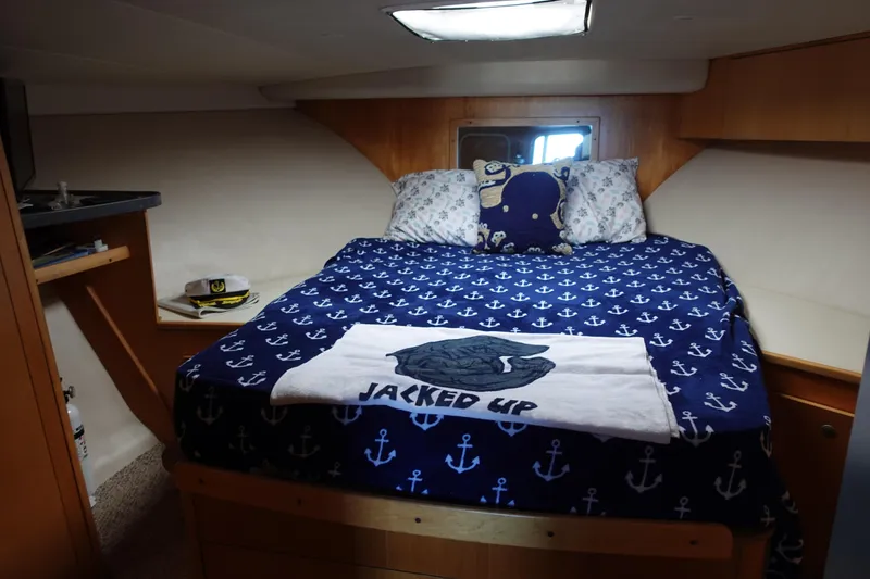 Slide: The Image of Cozy bedroom in 2001 Luhrs 36 Convertible boat with nautical-themed bedding. - 27