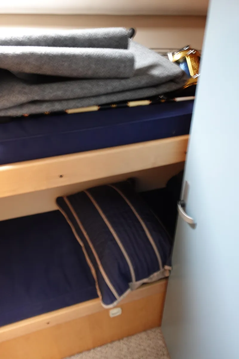 Slide: The Image of Bunk beds in 2001 Luhrs 36 Convertible boat cabin with blue bedding and striped pillow. - 29
