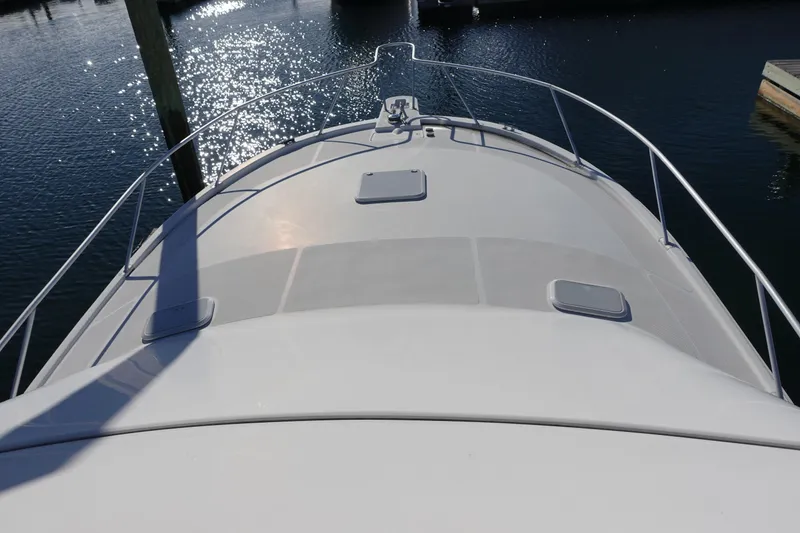 Slide: The Image of 2001 Luhrs 36 Convertible boat deck with railings, docked on calm water. - 7