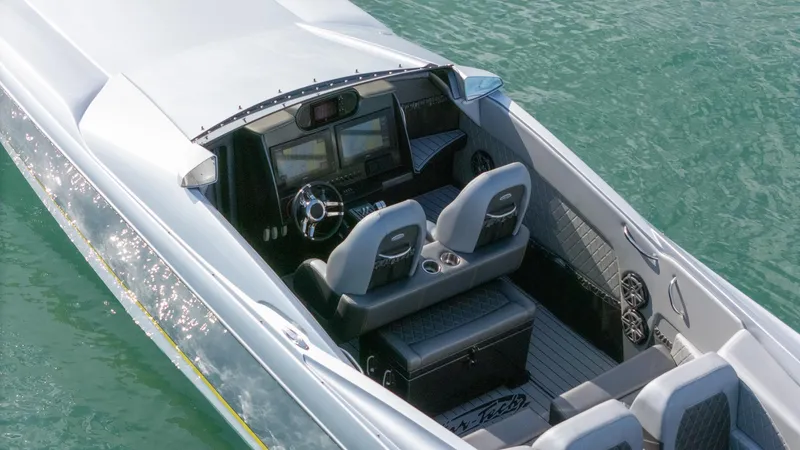 Slide: The Image of 2017 Nor-Tech 3900 Super-VEE boat interior with dual seats and modern dashboard on water. - 6