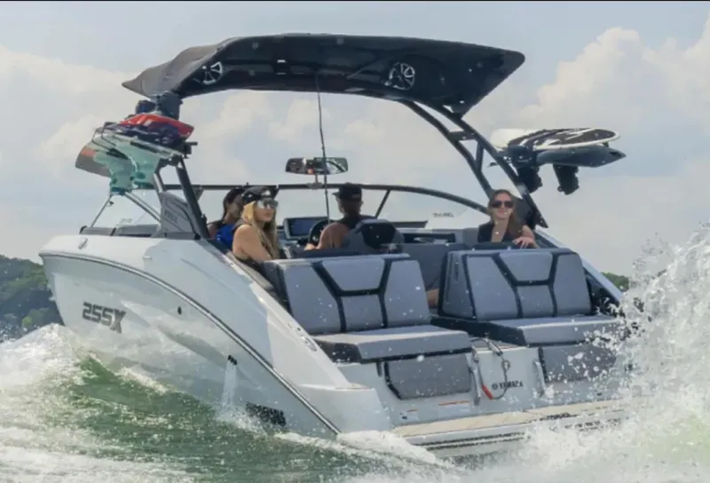 Slide: The Image of 2024 Yamaha Boats 255XE cruising on water with passengers enjoying the ride. - 1