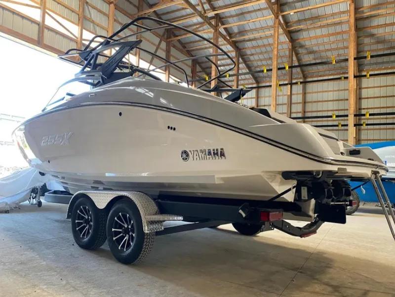 Slide: The Image of 2024 Yamaha Boats 255XE in a warehouse, on a trailer, showcasing sleek design. - 2
