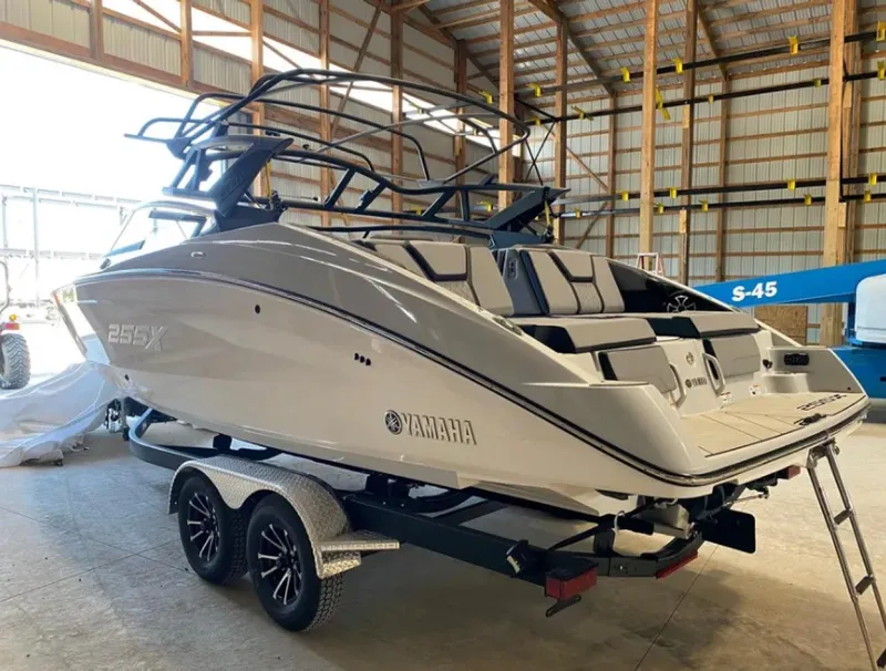 Slide: The Image of 2024 Yamaha Boats 255XE in a warehouse, on a trailer, showcasing sleek design. - 4