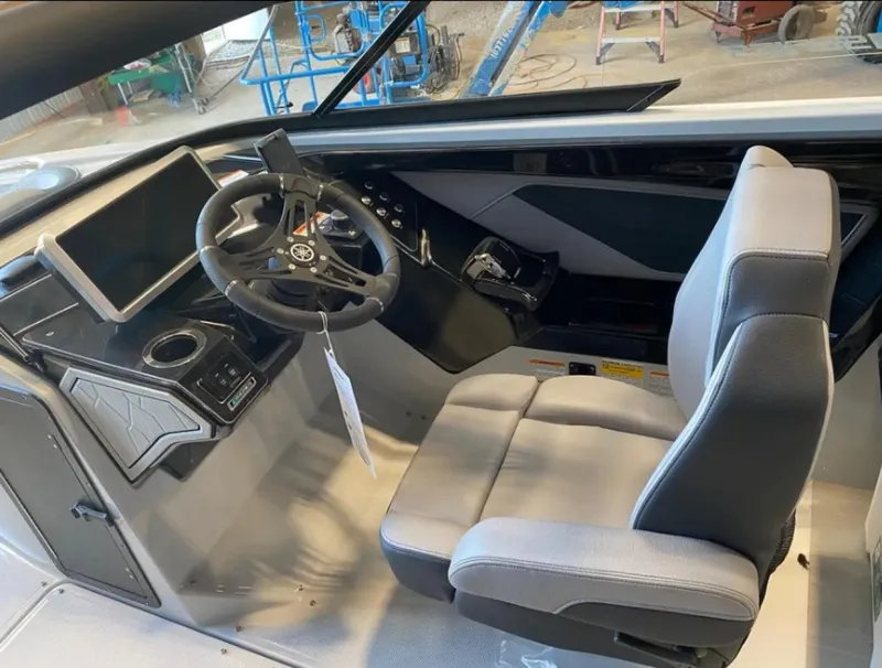 Slide: The Image of 2024 Yamaha Boats 255XE cockpit with steering wheel, modern controls, and comfortable seating. - 8