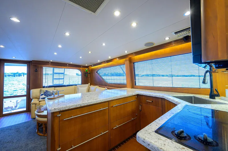 Slide: The Image of Luxurious interior of 2001 Hatteras 60 Convertible yacht with modern kitchen and seating area. - 16