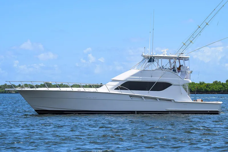 Slide: The Image of 2001 Hatteras 60 Convertible yacht on calm water under blue sky. - 4