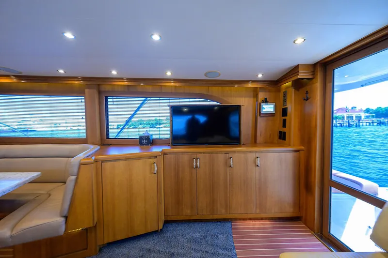 Slide: The Image of Luxurious interior of 2001 Hatteras 60 Convertible yacht with wood cabinetry and TV. - 7