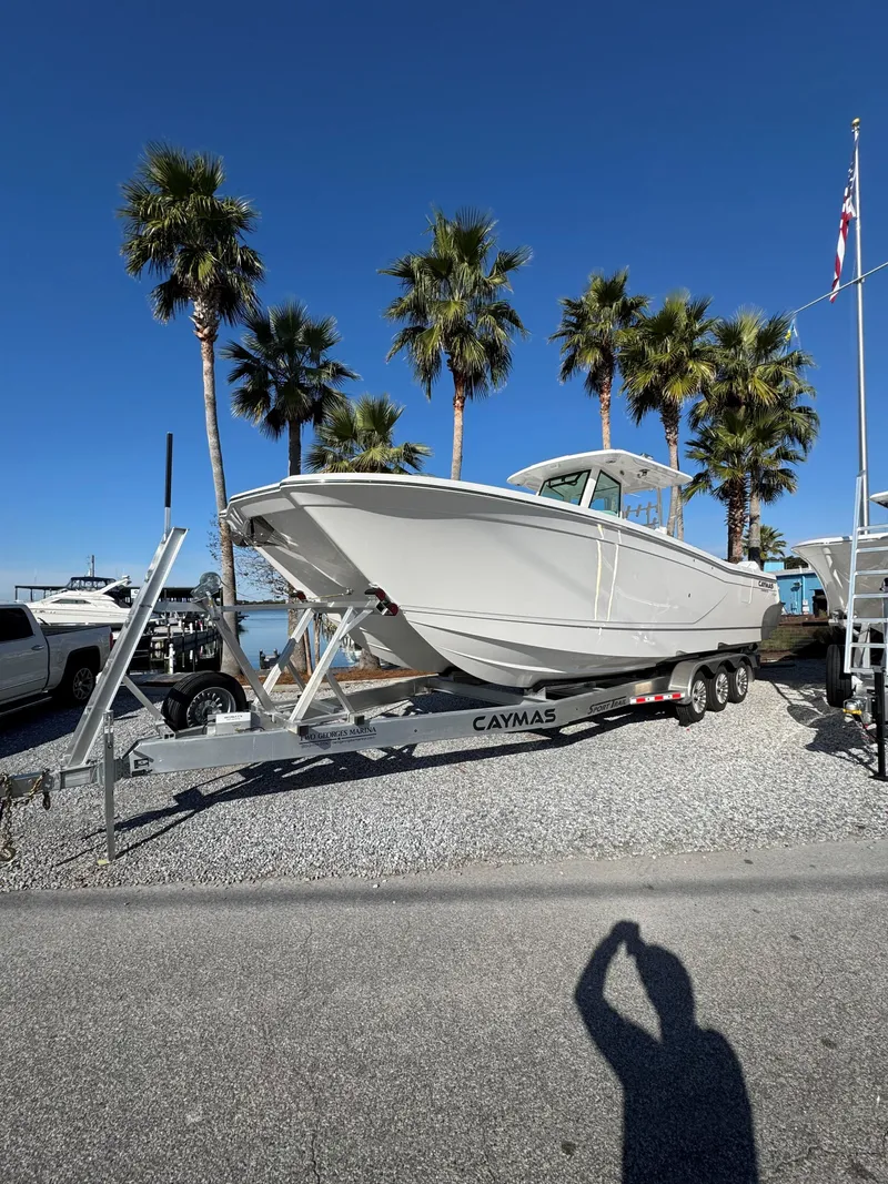 Slide: The Image of 2025 Caymas 34 CT boat on trailer, palm trees in background. - 1