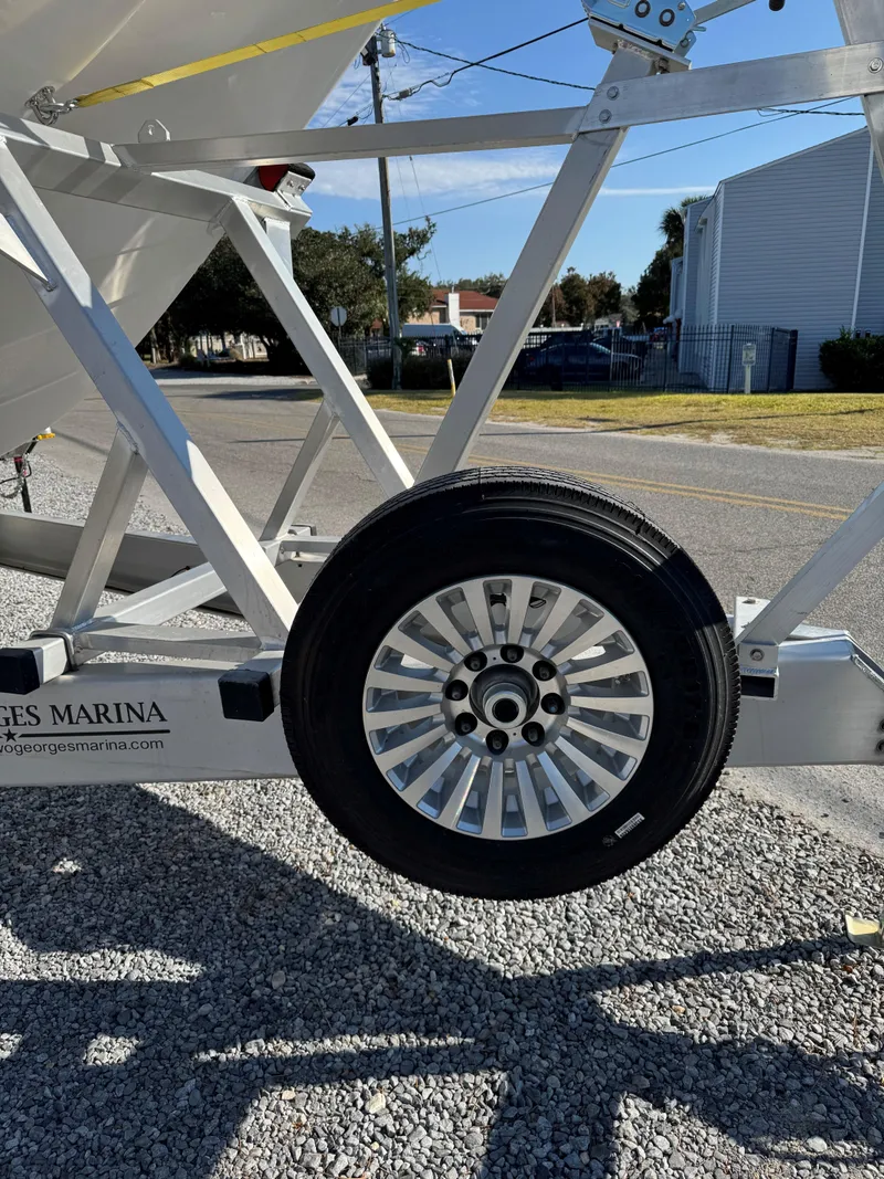 Slide: The Image of 2025 Caymas 34 CT boat trailer wheel on gravel road. - 10
