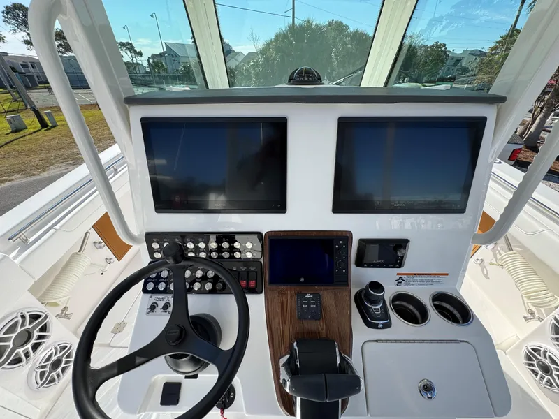 Slide: The Image of 2025 Caymas 34 CT boat dashboard with dual screens and steering wheel. - 13