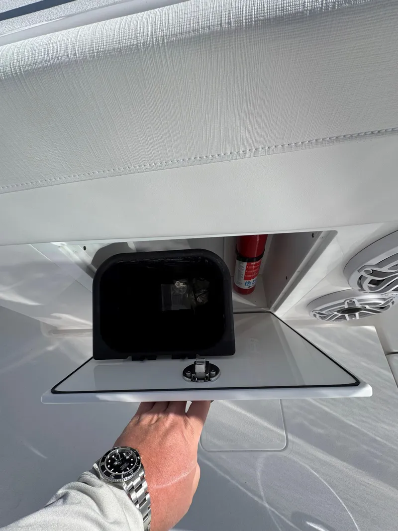 Slide: The Image of 2025 Caymas 34 CT boat interior storage compartment with fire extinguisher and speaker. - 25