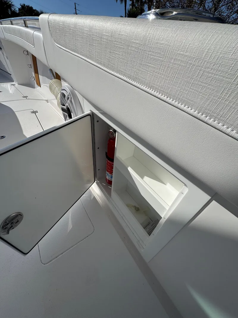 Slide: The Image of 2025 Caymas 34 CT boat interior with open storage compartment and fire extinguisher. - 32