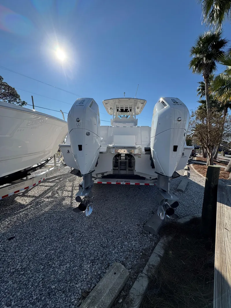 Slide: The Image of 2025 Caymas 34 CT boat with dual engines, parked on gravel under a clear sky. - 4