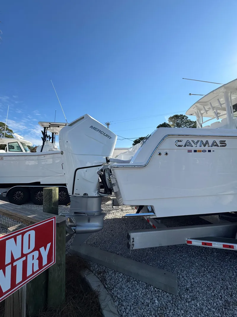 Slide: The Image of 2025 Caymas 34 CT boat with Mercury outboard engines, parked on gravel. - 5
