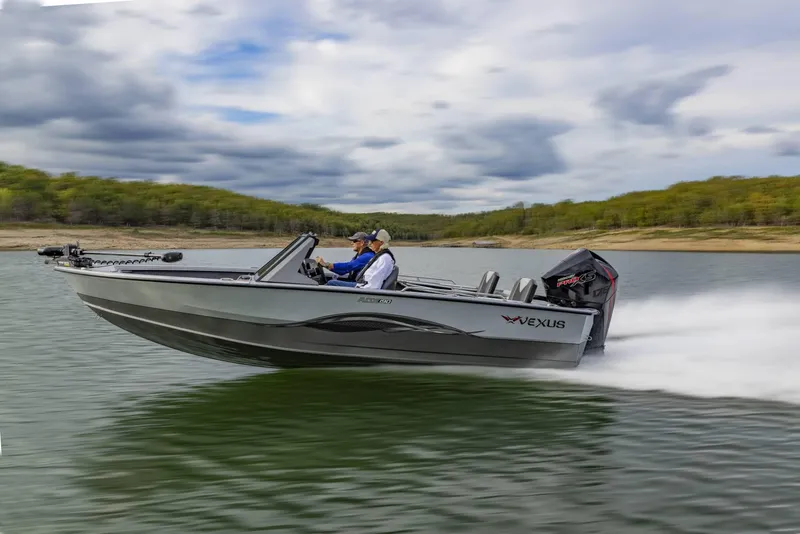 The Image of 2025 Vexus ADX190 boat speeding on a lake under a cloudy sky. - 1