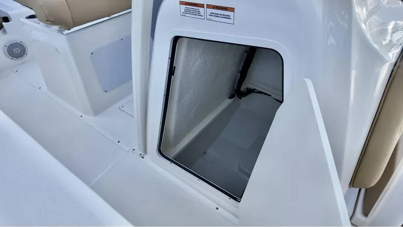 Slide: The Image of 2025 Bayliner Trophy 22 CC storage compartment with open hatch, showcasing interior space. - 18