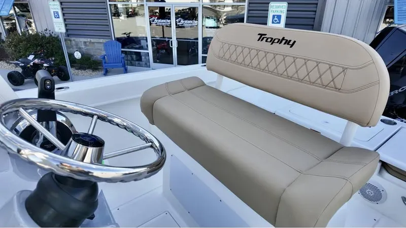 Slide: The Image of 2025 Bayliner Trophy 22 CC boat interior with steering wheel and cushioned seating. - 8