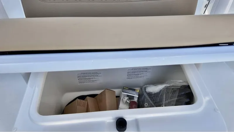 Slide: The Image of Storage compartment of 2025 Bayliner Trophy 22 CC boat, containing various items. - 16