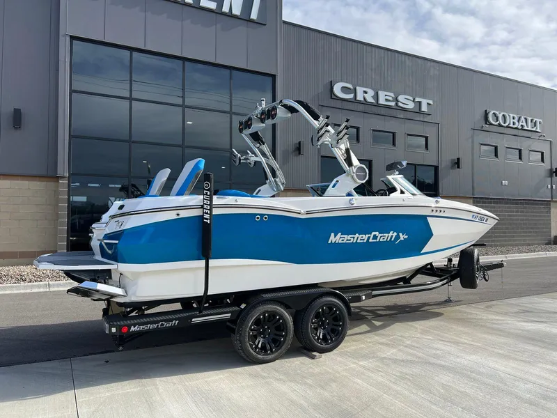 Slide: The Image of 2018 MasterCraft XStar boat in blue and white, parked outside dealership. - 3