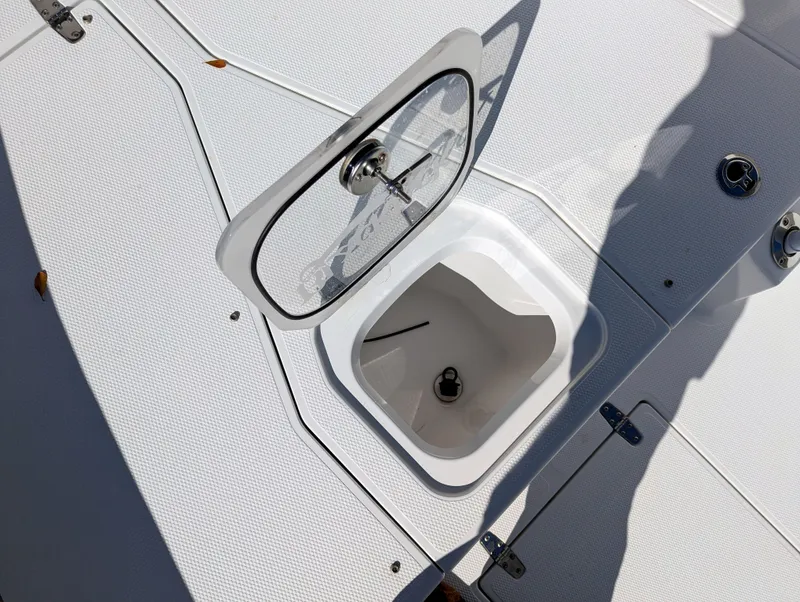 Slide: The Image of Open hatch on 2025 BlackJack 256 Coastal boat deck, showing storage compartment. - 17