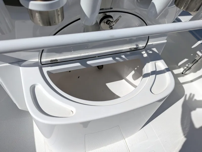 Slide: The Image of 2025 BlackJack 256 Coastal boat interior detail with storage compartment and rod holders. - 19