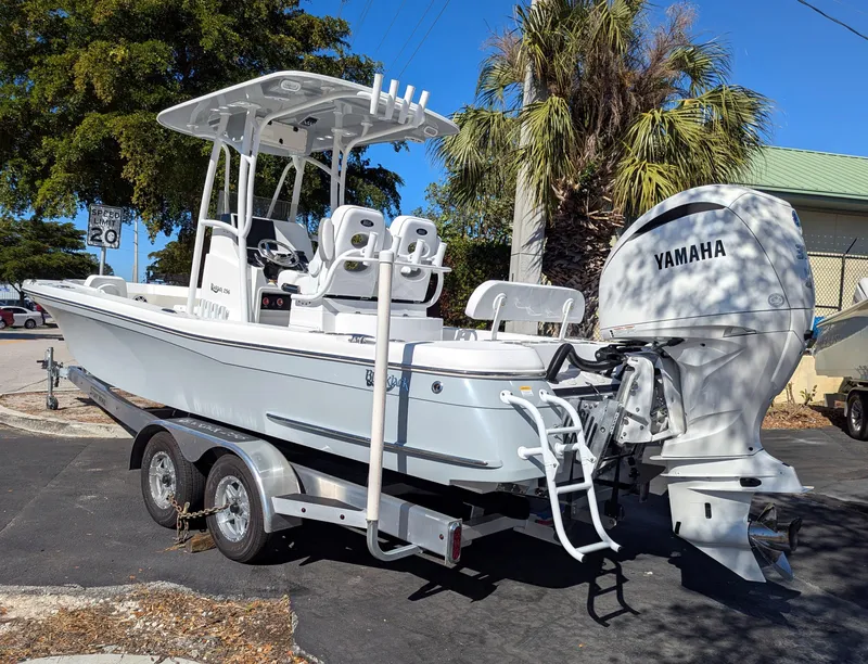 Slide: The Image of 2025 BlackJack 256 Coastal boat with Yamaha engine on trailer, parked outdoors. - 2