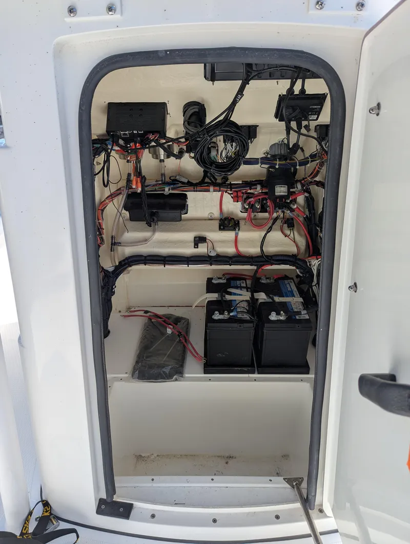 Slide: The Image of 2025 BlackJack 256 Coastal boat electrical compartment with wiring and batteries. - 22
