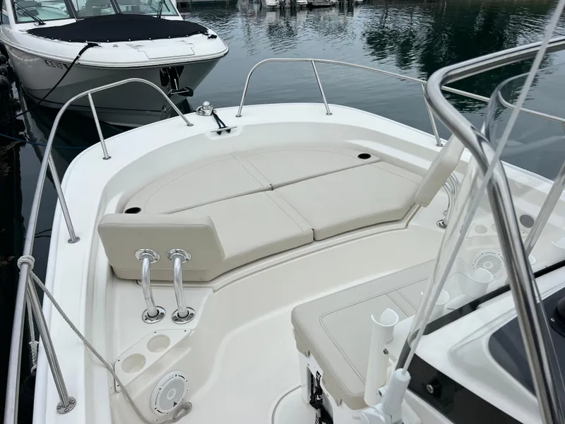 Slide: The Image of 2022 Boston Whaler 210 Montauk boat interior with cushioned seating and stainless steel railings. - 2