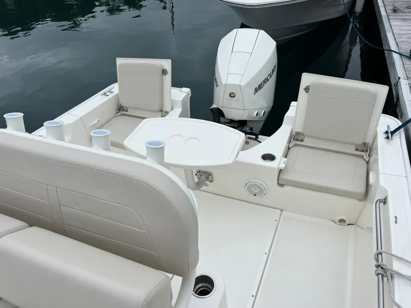 Slide: The Image of 2022 Boston Whaler 210 Montauk boat interior with seating and Mercury outboard motor. - 4