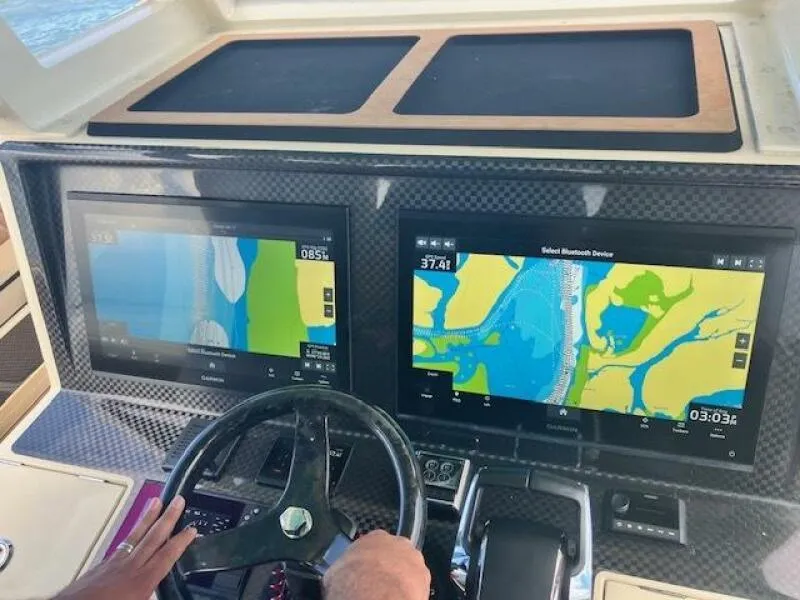 Slide: The Image of Boat dashboard with dual navigation screens, BlueCat 2025 model, carbon fiber finish. - 2