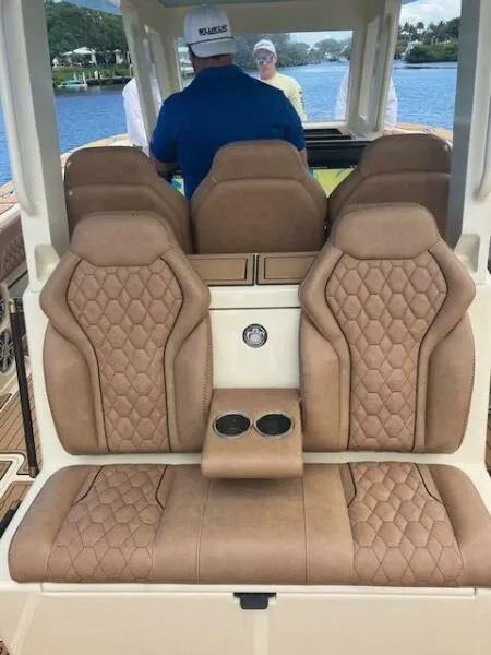 Slide: The Image of Luxurious seating on 2025 BlueCat 30 Fiberglass/30 Carbonfiber boat, featuring tan upholstery and cup holders. - 3
