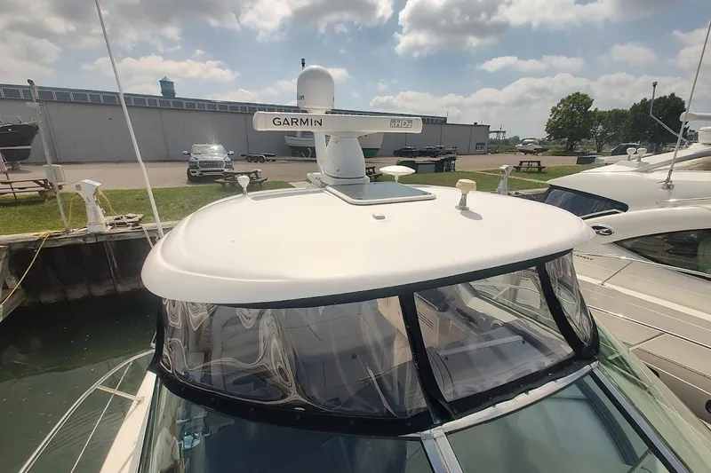 Slide: The Image of 2009 Sea Ray 380 Sundancer yacht with Garmin radar, docked under a partly cloudy sky. - 19