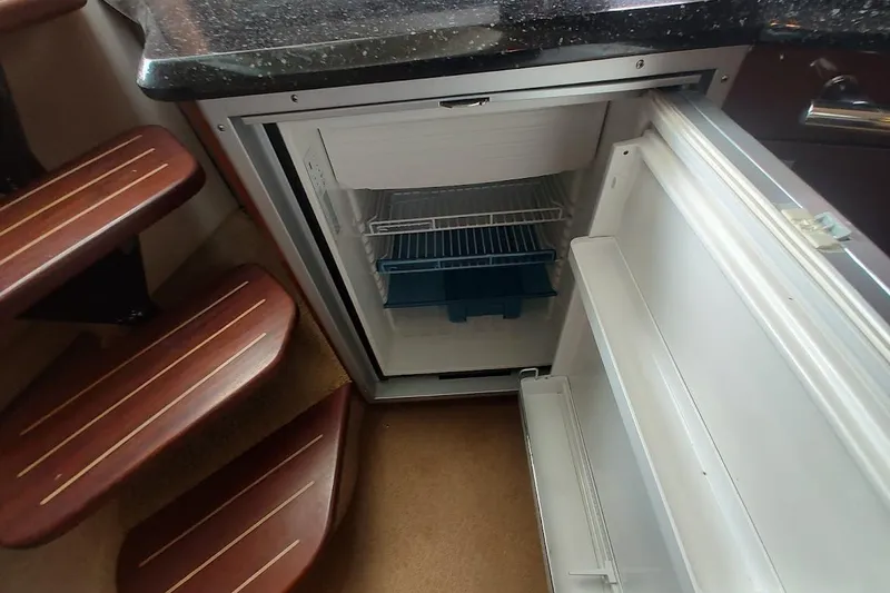 Slide: The Image of Open refrigerator in 2009 Sea Ray 380 Sundancer yacht interior, near wooden steps. - 23