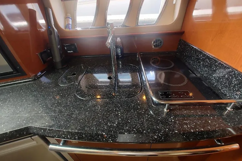 Slide: The Image of Luxurious galley kitchen in 2009 Sea Ray 380 Sundancer yacht with sleek countertops. - 27
