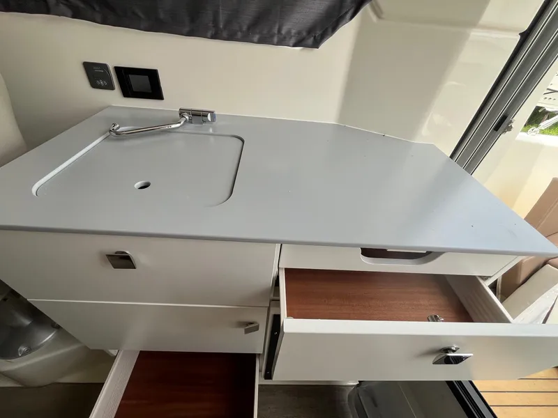 Slide: The Image of Interior of 2025 Bayliner Trophy T25 Explorer with sink and open storage drawers. - 12