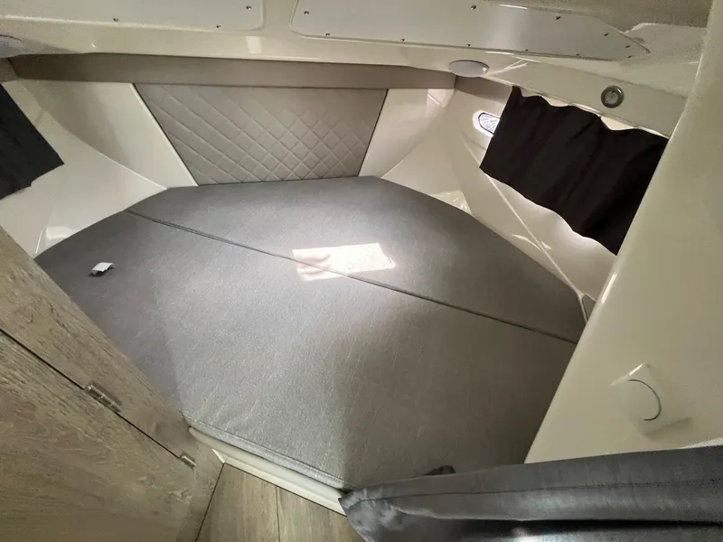 Slide: The Image of 2025 Bayliner Trophy T25 Explorer cabin interior with cushioned sleeping area and modern design. - 16