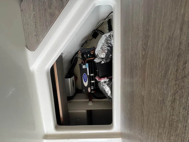 Slide: The Image of 2025 Bayliner Trophy T25 Explorer interior compartment with equipment and wiring. - 19