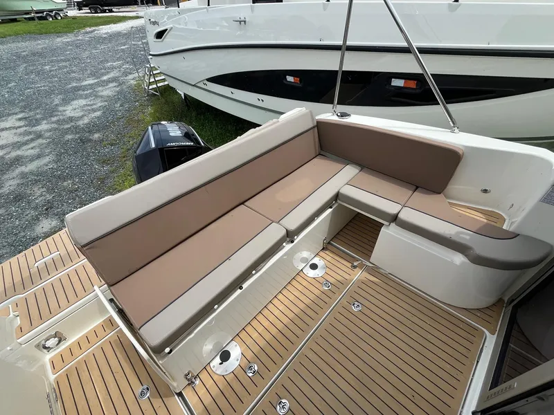 Slide: The Image of 2025 Bayliner Trophy T25 Explorer boat interior with cushioned seating and teak flooring. - 22