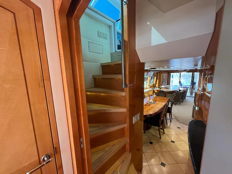 Slide: The Image of Interior of 2004 Hatteras 80 Motor Yacht with wooden stairs and elegant dining area. - 15