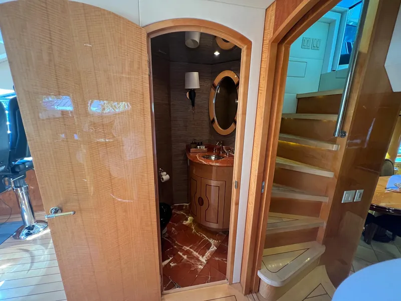 Slide: The Image of Interior of 2004 Hatteras 80 Motor Yacht featuring a bathroom and wooden staircase. - 16