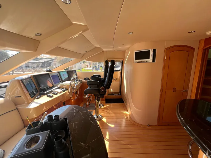 Slide: The Image of Luxurious 2004 Hatteras 80 Motor Yacht helm with modern navigation equipment and plush seating. - 18