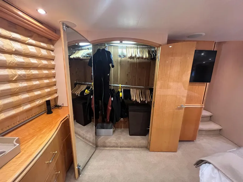 Slide: The Image of Luxurious 2004 Hatteras 80 Motor Yacht interior with spacious closet and elegant wood finishes. - 28