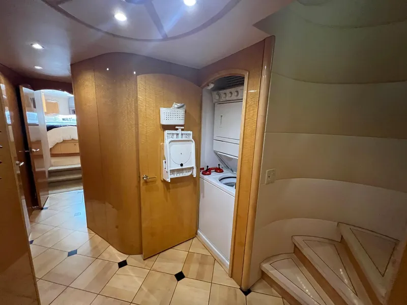 Slide: The Image of Interior of 2004 Hatteras 80 Motor Yacht with laundry area and wooden staircase. - 36