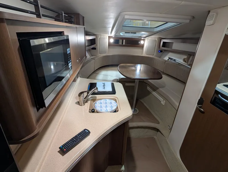 Slide: The Image of Interior of 2015 Sea Ray 280 Sundancer with kitchenette and seating area. - 10