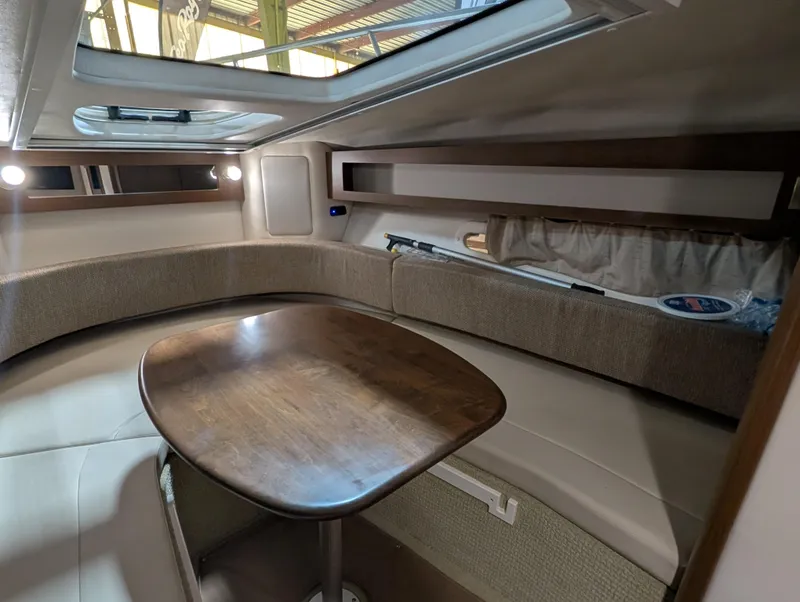 Slide: The Image of Interior of 2015 Sea Ray 280 Sundancer with cozy seating and wooden table. - 11